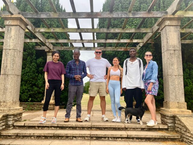 Everyday English participants and group leader standing and smiling for a photo together