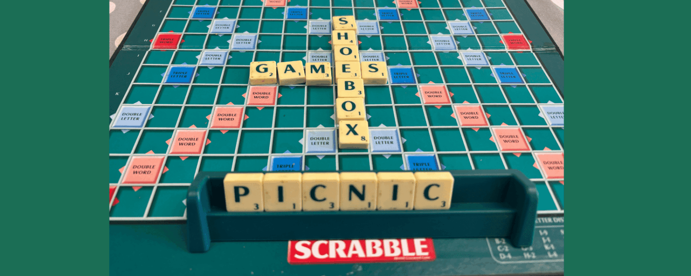Scrabble board with Shoebox games and picnic on the board